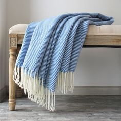 a blue and white blanket sitting on top of a wooden bench