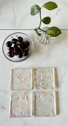 marbled coasters with cherries in a bowl and green plant on the table