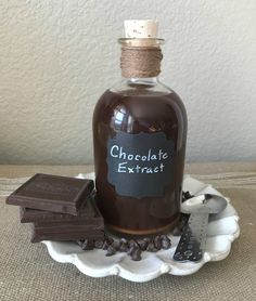 a bottle filled with chocolate sitting on top of a plate next to pieces of chocolate