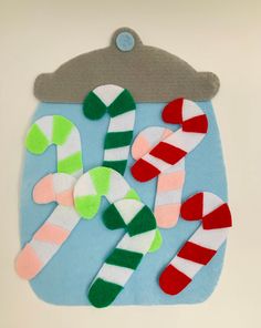 an ornament made out of felt with candy canes and hats on it