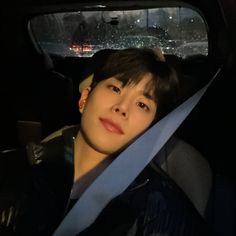 a young man sitting in the back seat of a car with his head hanging out