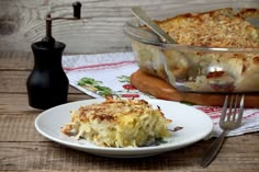 a white plate topped with food next to a casserole dish