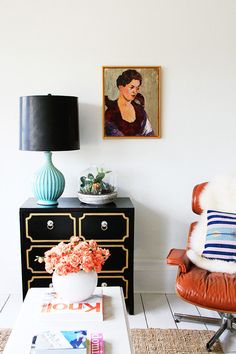 a living room with a chair, table and painting on the wall