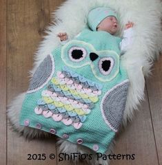 a baby sleeping on top of an owl blanket