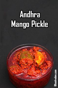 there is a small bowl filled with food on top of a black surface and the words, andra mango pickle