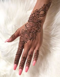 a woman's hand with henna tattoos on it