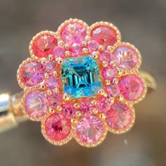 Discover the epitome of elegance with our Teal Tourmaline and Pink Spinel Halo Ring. Crafted in luxurious 14K gold, this stunning masterpiece showcases a mesmerizing teal tourmaline center encircled by a vibrant pink spinel halo. Elevate your style with this unique colored gemstone fusion - a timeless treasure for the sophisticated soul. 💍✨ This piece is sold, please do not order from this link. I put the listing here to showcase the design. Please message me if you are interested to customize Engagement Rings Pink, Bespoke Jewellery Design, Rings Pink, Blue Engagement Ring, Pink Spinel, Engagement Ring Rose Gold, Pink Bling, Blue Tourmaline, Pink Jewelry