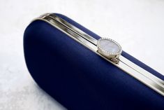 The Navy Bella Clutch is a custom designer clutch, and a timeless choice for an elegant wedding handbag. We’ve found your something blue… Your bridal purse. The Navy Bella Clutch is the perfect option for an evening wedding, as the duchess satin feels luxurious and sensible, without sacrificing style. Perhaps you’re celebrating on the New England coast at a chic hotel or private estate, complete your look with a stylish and elevated custom purse that you’ll love for years to come. The Bella Clut Modern Clutch With Detachable Handle For Formal Events, Luxury Compact Evening Clutch, Modern Blue Clutch For Formal Occasions, Timeless Rectangular Clutch With Magnetic Closure, Classic Formal Clutch Evening Bag, Elegant Compact Evening Bag For Formal Occasions, Classic Evening Bag For Wedding, Classic Formal Evening Clutch Bag, Classic Evening Clutch With Magnetic Closure