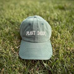 Introducing the cozy and stylish Plant Daddy hat from Plant Scouts - your one-stop-shop for all things plants. This hat is not only a functional accessory to protect you from the sun while you care for your indoor oasis, but it also serves as a reminder of your love and dedication to your beloved plants. The playful "Plant Daddy" text on the hat brings a smile to your face and lets others know that you're proud of your green thumb. So, whether you're relaxing in your backyard or tending to your Everyday Brimmed Dad Hat, Green Visor Hat For Everyday, Adjustable Brimmed Dad Hat For Everyday, Green Brimmed Everyday Hat, Green Brimmed Hat For Everyday Wear, Comfortable Curved Brim Hat, Outdoor Dad Hat, Outdoor Brimmed Dad Hat, Comfortable Outdoor Hat With Curved Brim