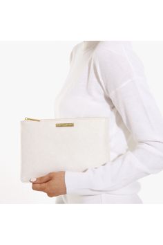 a woman holding a white purse in her hands