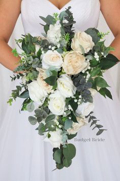 a bridal holding a bouquet of white roses and greenery