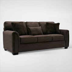 a brown couch with some pillows on it's back and one arm folded down