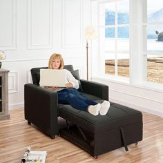 a woman sitting in a chair with a laptop on her lap