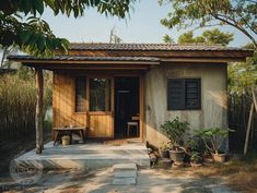 a small house with potted plants in front of it and an open door on the outside