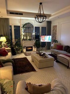 a living room filled with furniture and a flat screen tv mounted to the wall in front of a fire place