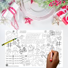 a person holding a marker over a christmas coloring page with presents and decorations around it