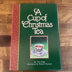 a cup of christmas tea book sitting on top of a wooden table