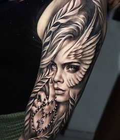 a woman's arm with an angel and cross tattoo on the left side of her arm