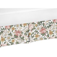 a white bed with pink flowers and green leaves on the headboard, against a white background