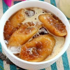 a bowl filled with bananas sitting on top of a blue and white striped table cloth