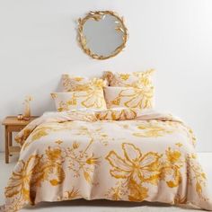 a bed with yellow flowers on it and a round mirror