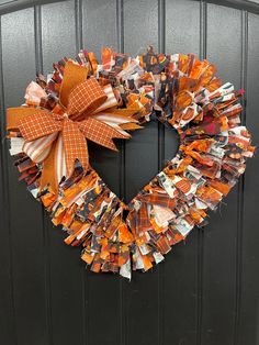 a wreath made out of magazines is hanging on the front door with an orange bow