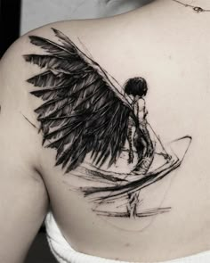 a woman with an angel wing tattoo on her back