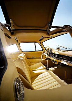 the interior of an old fashioned car with sun shining through the window and dash board