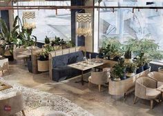 a restaurant with tables and chairs covered in plants