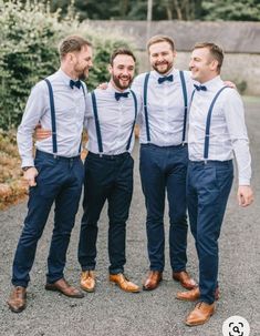 three men wearing blue pants and bow ties are smiling at the camera while standing together