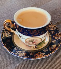 a blue and gold coffee cup on a saucer