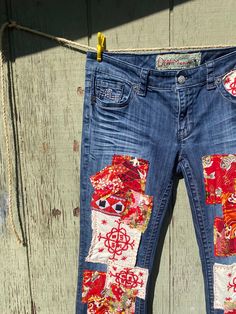 a pair of blue jeans with red and white patches on them