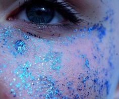 a woman with blue glitter on her face