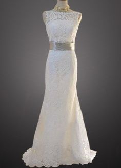 a white wedding dress on display in front of a black background