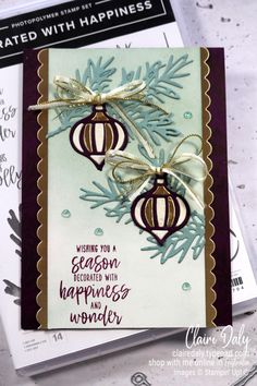 a close up of a greeting card with two ornaments on it and the words, wishing you a season decorated with happiness wonder