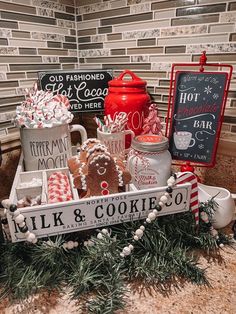 a tray with cookies and mugs sitting on top of a counter next to a sign