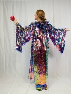 This sparkling maxi length kimono robe with bell sleeves is sure to make you stand out in the crowd. The iridescent holographic color shifting sequins catch sunlight and reflect a rainbow of colors all around you. These sleeves are incredible and like no other sequin kimono out there. It looks great on stage and is very demanding of attention. All eyes on you! It wears great from day to night, is unlined, and has a mesh foundation so it does not get too hot while you are dancing your heart out a Spring Party Robe With Kimono Sleeves, Long Multicolor Party Kimono, Multicolor Long Sleeve Party Kimono, Multicolor Long Sleeve Kimono For Party, Rave Kimono, Holographic Color, Burning Men, Sequin Kimono, Fire Rainbow