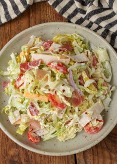 a white bowl filled with salad on top of a wooden table