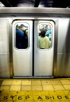 two people are standing in the doorway of a subway train