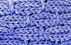 a close up view of a blue knitted cloth with small crochet stitches