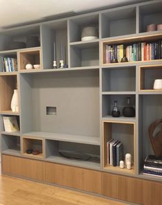 an image of a book shelf with many books on it and some vases in the middle