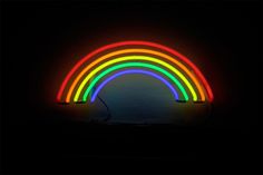 a neon rainbow light is lit up in the dark