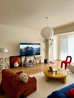 a living room filled with furniture and a flat screen tv on top of a wooden table