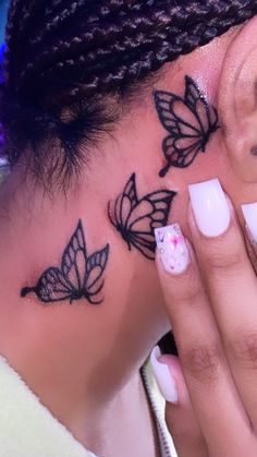 a close up of a person's face with butterfly tattoos on her left side