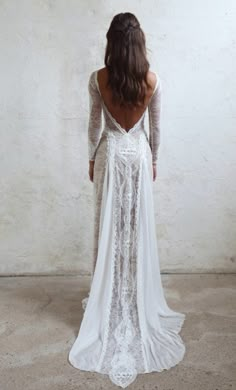 the back of a woman's wedding dress, with long sleeves and open shoulders