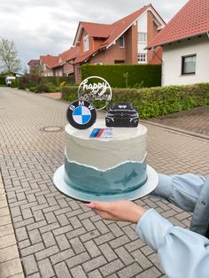 a person holding a cake in front of some houses