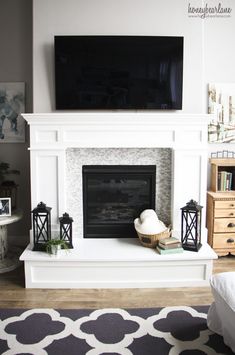 a living room with a white fireplace and television on the mantel over it's mantle