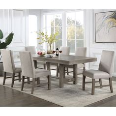 a dining room table with chairs and a vase