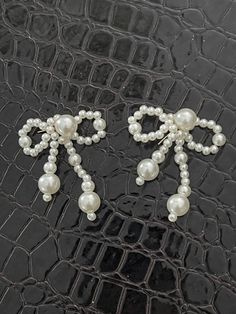 two pairs of pearls are attached to alligator skin