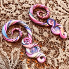 These gauged earrings are handcrafted with an intricate rainbow swirl of pearl, snow sparkle, pearl red, magenta, gold, lime green, navy blue, teal, violet, and lilac clay.  Wrapping around Opalite cabochons, looping at the bottom, and spiraling at the top! Opalite is a glass stone that promotes peace and a calm environment.  It assists in transition, opens up creative flow, helps to brighten the mind, and fights against negative thought patterns. Size: 2g All gauges are rubbed with coconut oil Handmade Swirl Earrings For Gifts, Handmade Swirl Earrings As Gift, Unique Swirl Earrings As Gift, Unique Swirl Earrings For Gifts, Artistic Handmade Swirl Jewelry, Snow Sparkle, Calm Environment, Thought Patterns, Polymer Clay Jewelry Tutorials